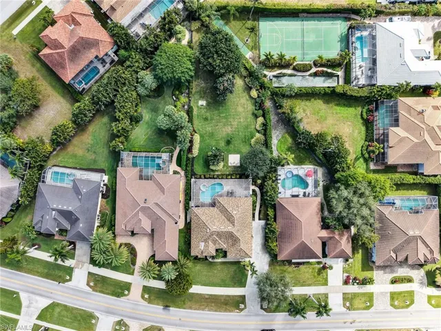 Aerial view of property's location featuring nearby suburban area and a pool area