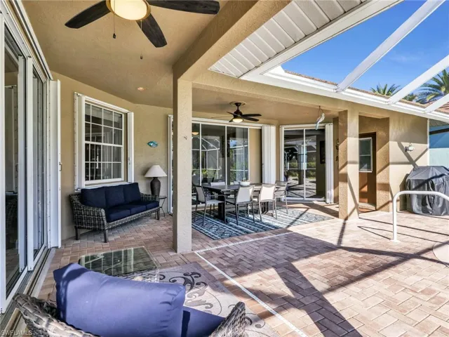 View of patio / terrace with a ceiling fan, outdoor dining area, a grill, and glass enclosure