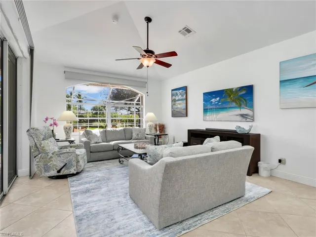 Living area featuring light tile patterned floors and ceiling fan