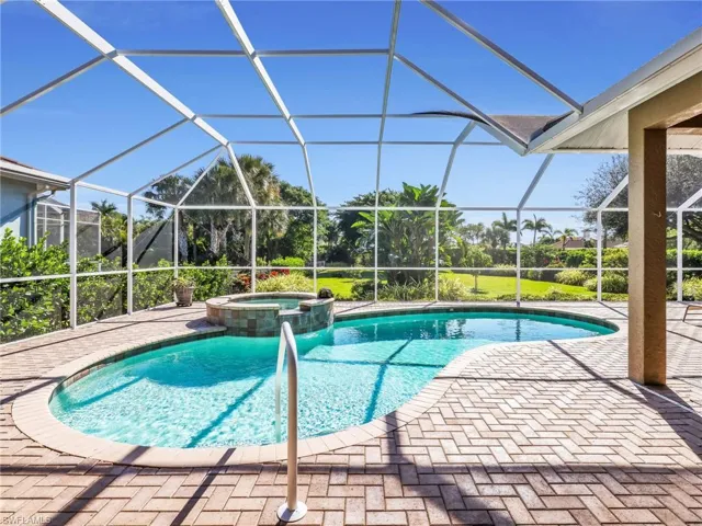 View of swimming pool featuring a sunroom, a pool with connected hot tub, a lanai, and a patio area