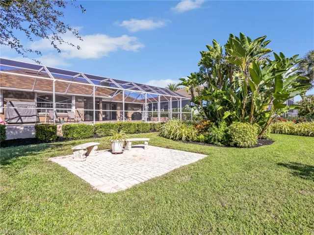 View of green lawn with a sunroom, a lanai, and a patio area