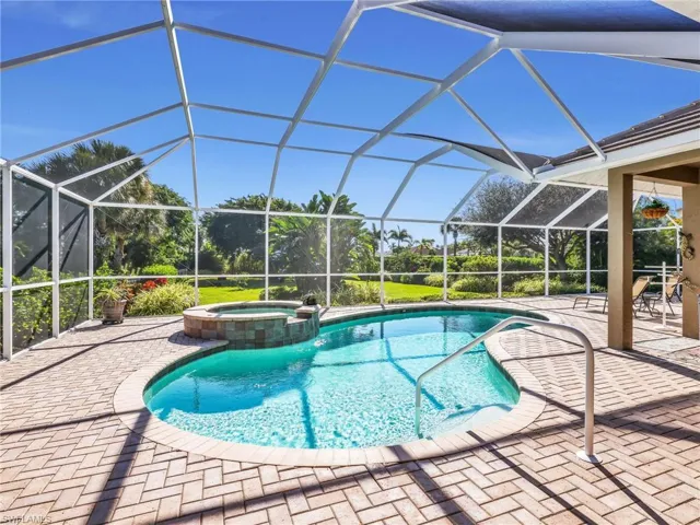View of swimming pool with a sunroom, a pool with connected hot tub, a patio area, and a lanai
