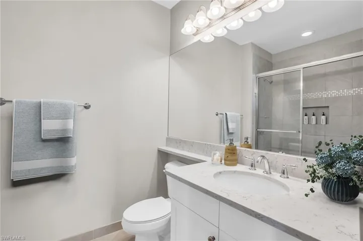 Bathroom with toilet and vanity with extensive cabinet space