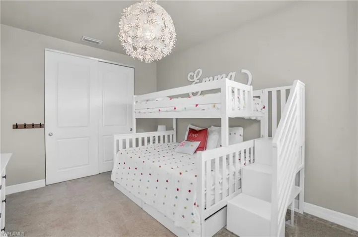 Bedroom featuring a notable chandelier and light colored carpet