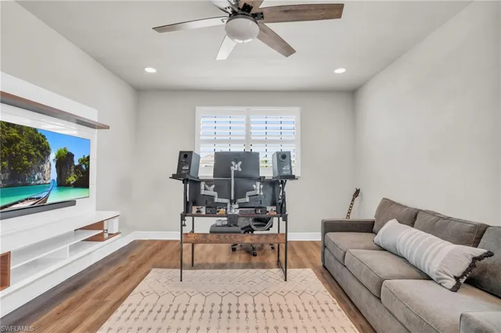 Office with hardwood / wood-style flooring and ceiling fan