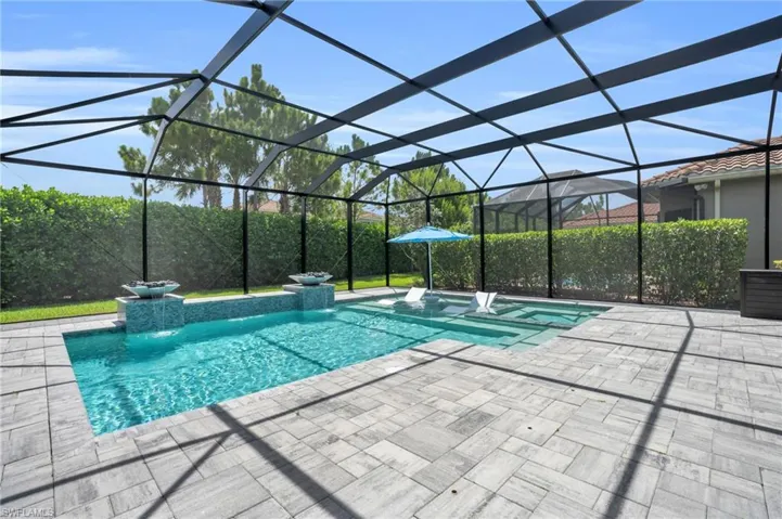 View of swimming pool with a patio, glass enclosure, and pool water feature