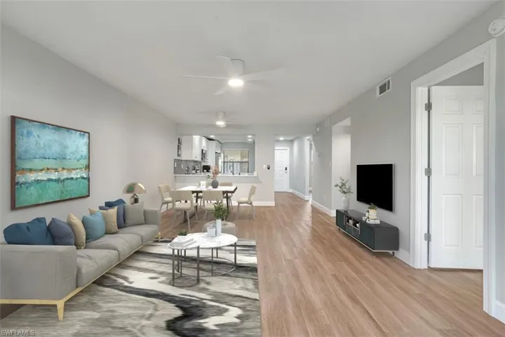 Living room with ceiling fan and light wood-style floors