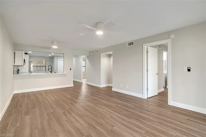Unfurnished living room with ceiling fan and light wood-type flooring