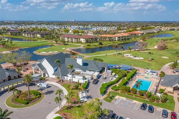 Aerial perspective of suburban area featuring a local golf course and a nearby body of water