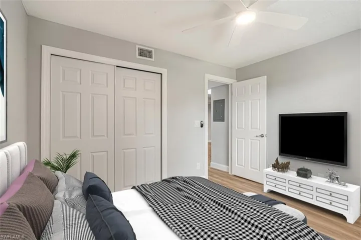 Bedroom featuring light wood-type flooring, a closet, electric panel, and a ceiling fan