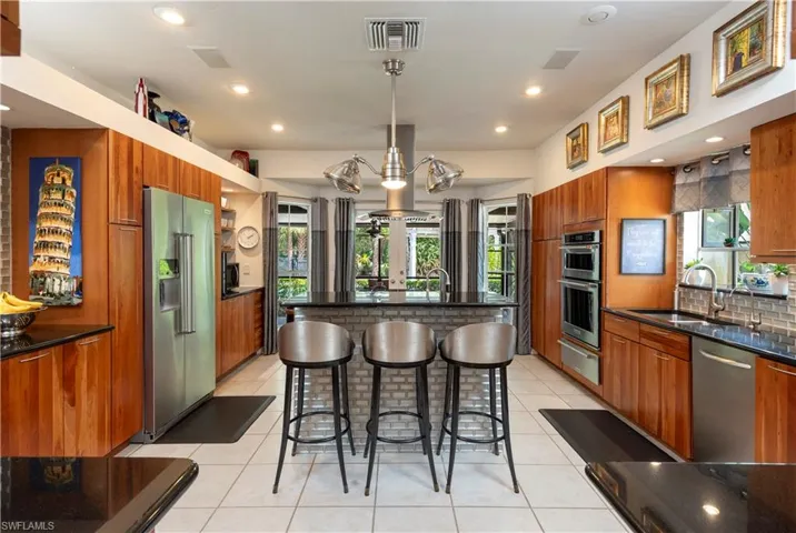 Kitchen featuring cherry cabinets, 2 sinks, stainless steel appliances and granite countertops