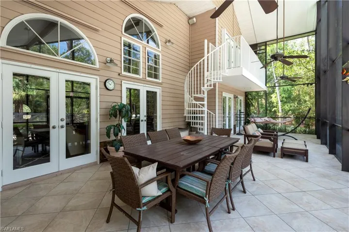 Covered, Screened Lanai and outdoor eating space with stairs leading to Master Bedroom