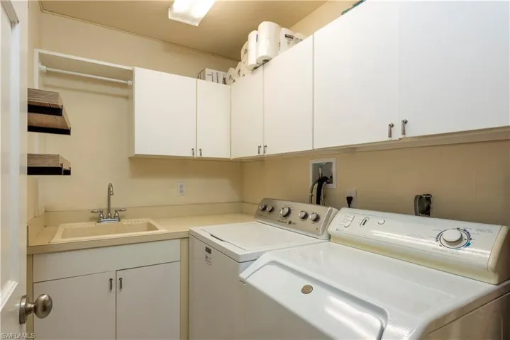 Laundry area featuring a sink, cabinet space, and independent washer and dryer