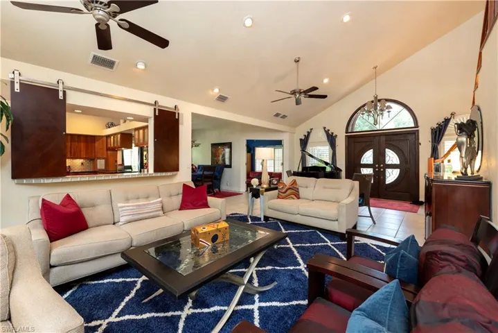 Living area featuring recessed lighting, ceiling fans, and vaulted ceiling