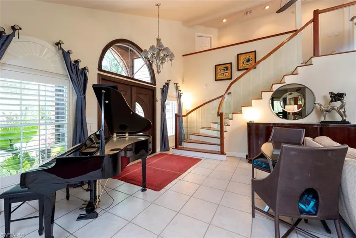 Foyer entrance featuring vaulted ceilings and sweeping staircase with cherry details