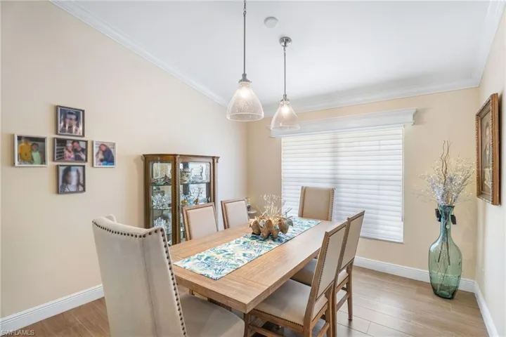 Dining space featuring light wood-style flooring, baseboards, and crown molding