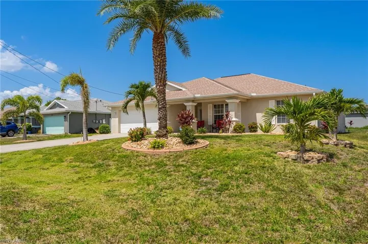Ranch-style house featuring concrete driveway, an attached garage, stucco siding, and a front yard