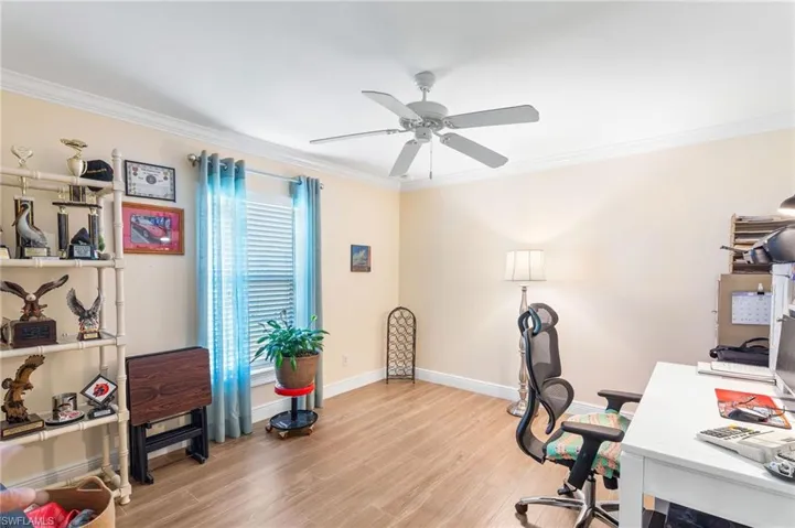Office featuring ornamental molding, a ceiling fan, light wood-type flooring, and baseboards