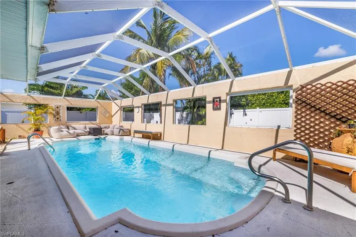 Outdoor pool with a patio and glass enclosure