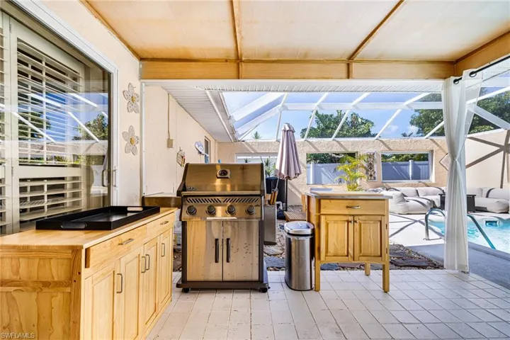View of patio / terrace featuring glass enclosure and area for grilling