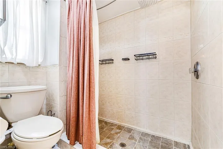Full bathroom featuring tile walls and a tile shower