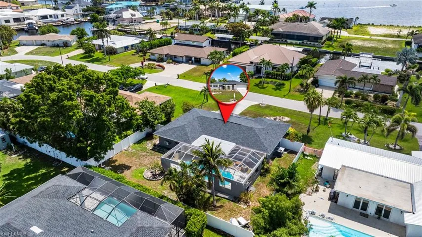 Aerial perspective of suburban area with a pool and a nearby body of water