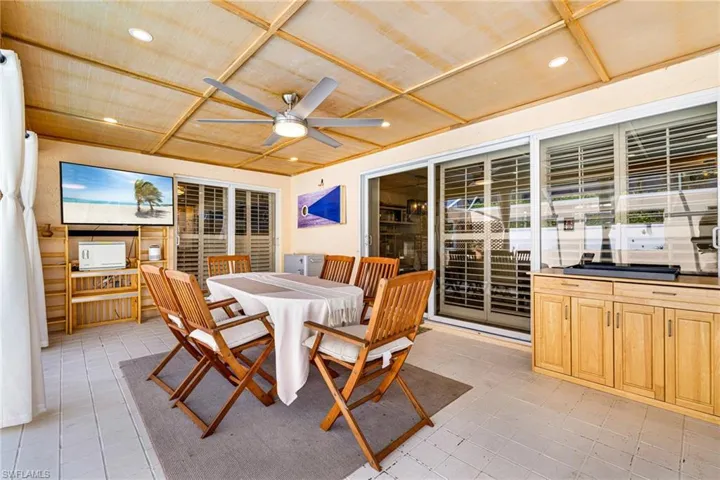 Sunroom with a ceiling fan and outdoor dining area