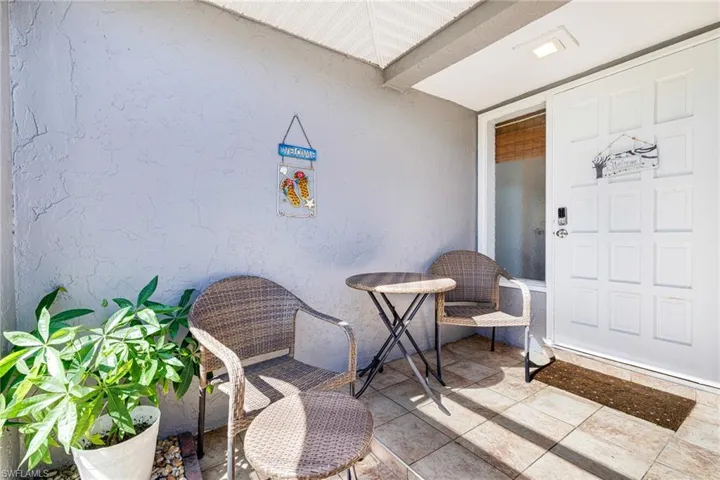 Entrance to property with stucco siding and a patio
