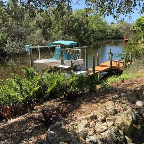 View of dock with a water view and a wooded view