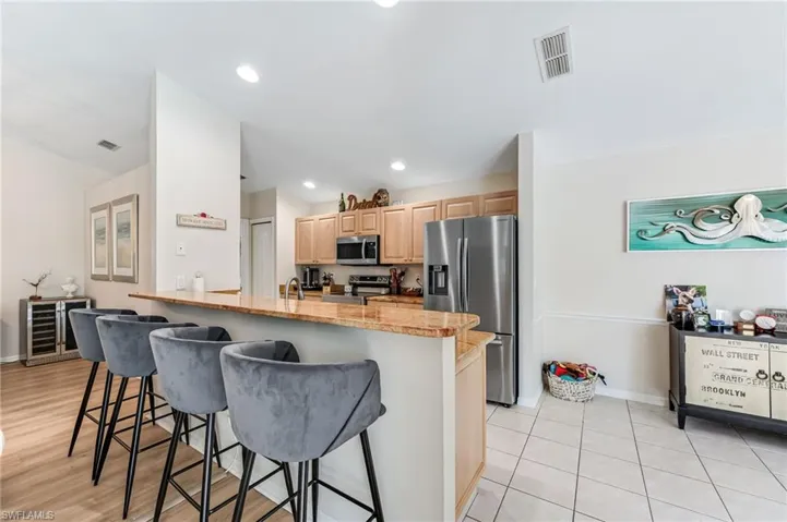 Kitchen featuring granite counter tops, stainless steel appliances, breakfast bar and eat in area
