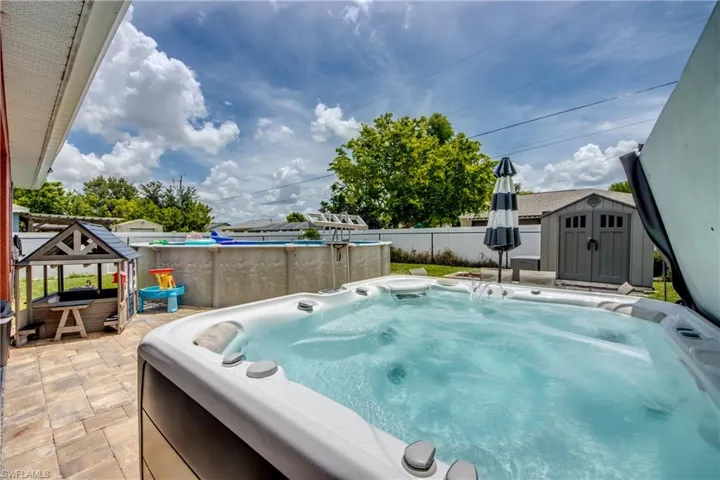 View of swimming pool featuring a hot tub, a shed, and a swimming pool