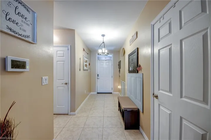Entryway featuring light tile patterned floors and a chandelier