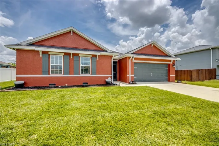 Single story home with a garage, stucco siding, and concrete driveway