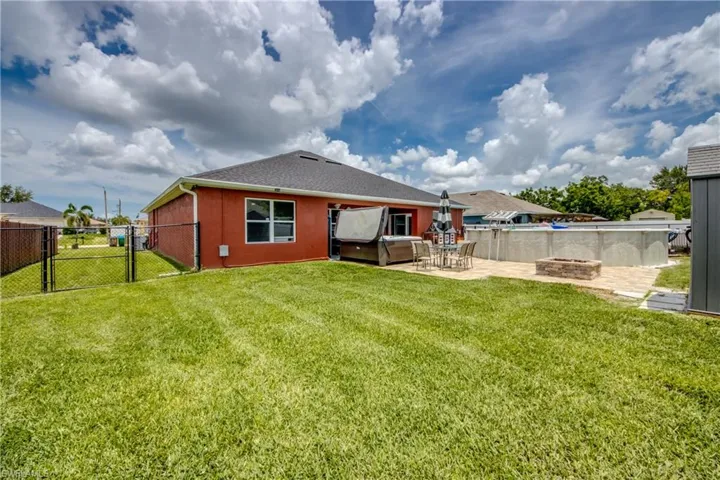 Rear view of property featuring a gate, an outdoor fire pit, a fenced backyard, a patio, and a shingled roof