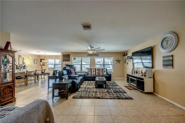 Living room featuring plenty of natural light, a ceiling fan, and light tile patterned flooring