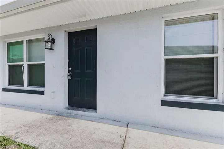 Entrance to property with stucco siding