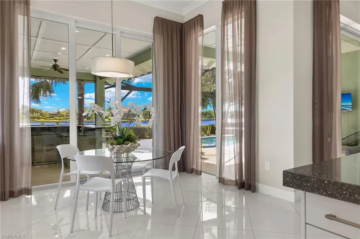 Tiled dining area with ceiling fan and plenty of natural light