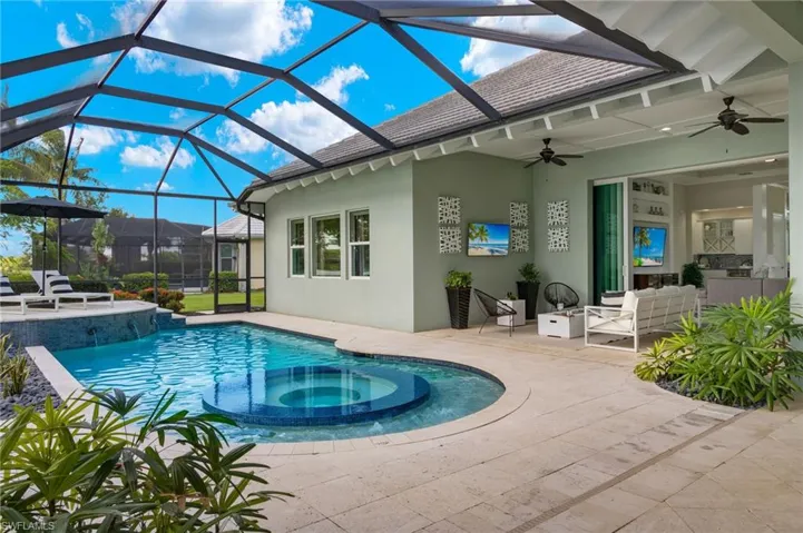 View of swimming pool with an in ground hot tub, a lanai, outdoor lounge area, a patio, and ceiling fan