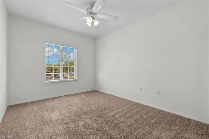 Carpeted empty room with baseboards and ceiling fan