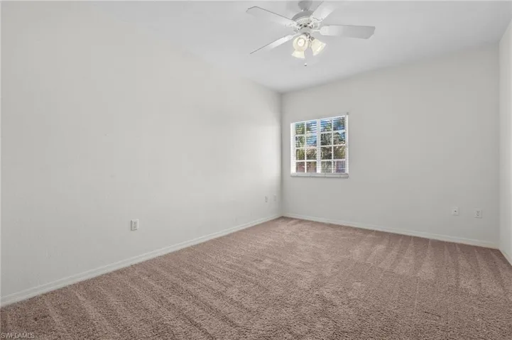 Unfurnished room featuring carpet floors and ceiling fan