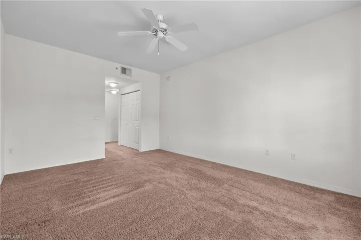 Spare room featuring carpet and ceiling fan