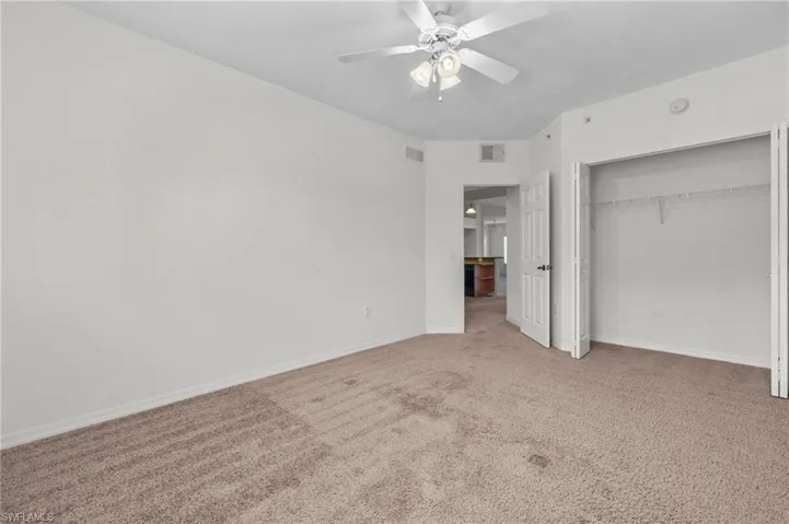 Unfurnished bedroom featuring carpet floors, a closet, and a ceiling fan