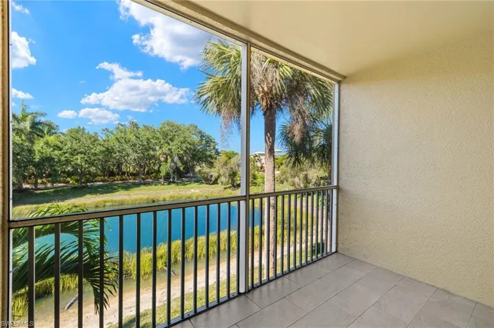 Balcony featuring a sunroom and a water view