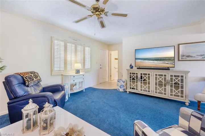 Living room looking toward entry door and half bath.  Note: condo has plantation shutters.