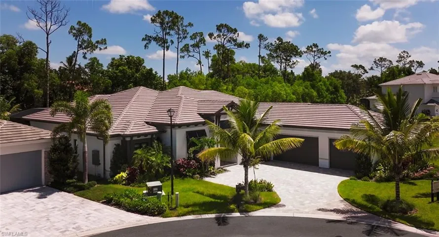 View of front of property featuring a tile roof, a garage, driveway, a front yard, and stucco siding