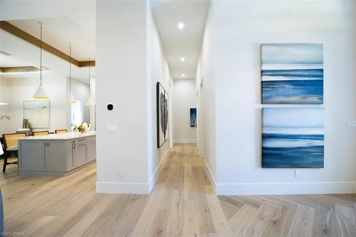 Corridor with parquet flooring and recessed lighting