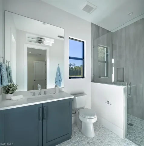 Bathroom with a stall shower, vanity, and light tile patterned floors