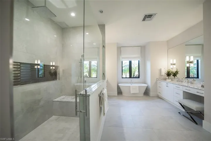 Bathroom with vanity, a shower stall, a soaking tub, recessed lighting, and light tile patterned floors