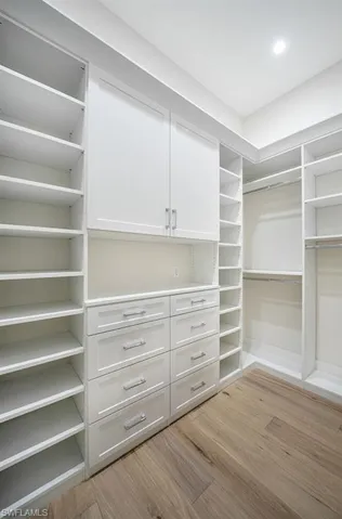 Walk in closet with light wood-style floors