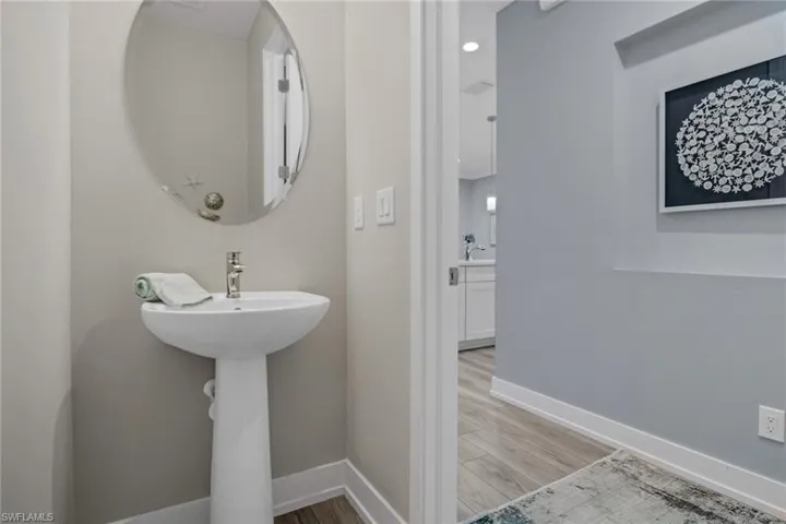 Half bath with baseboards and light wood-style floors
